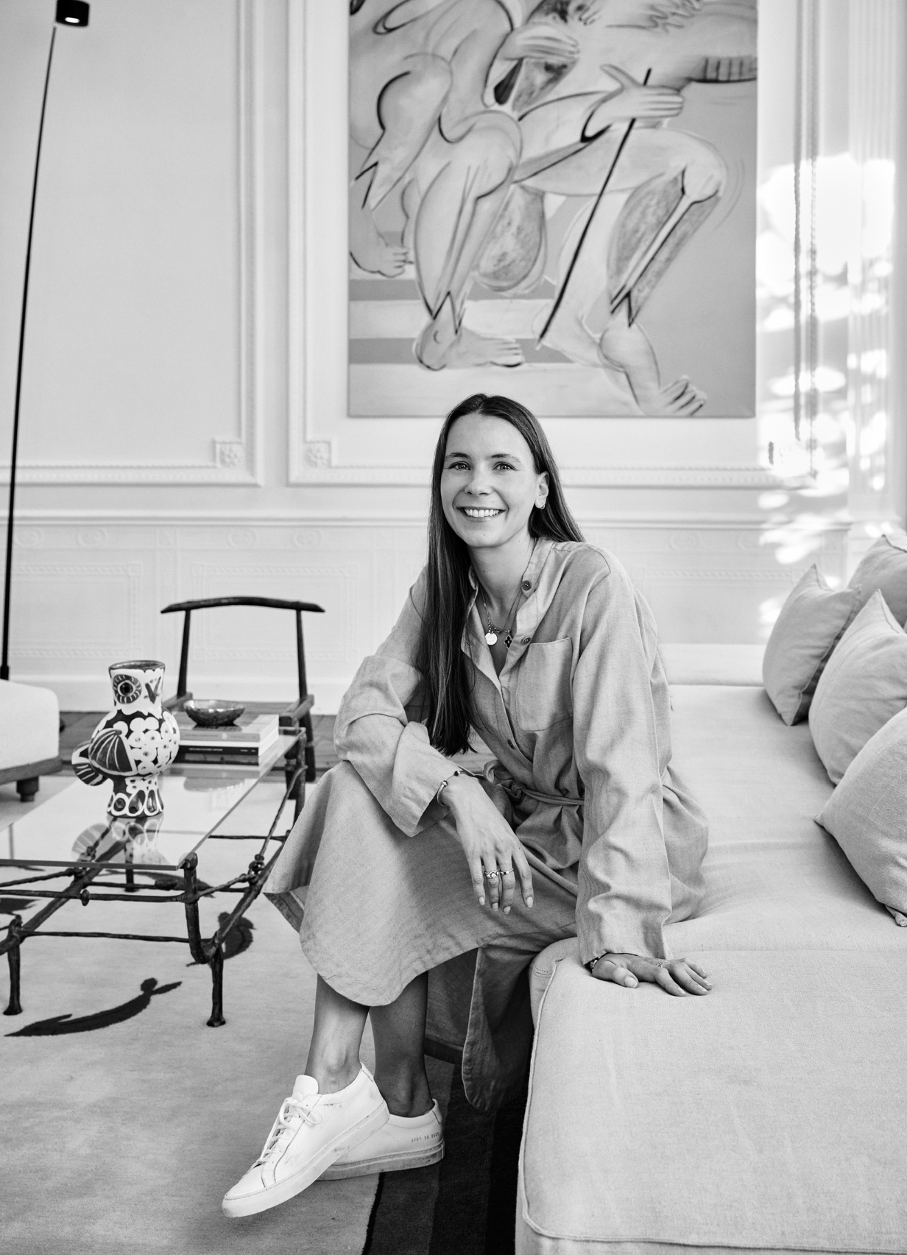 Astrid Carbonez seated in a panelled interior beneath a large figurative painting